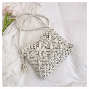 Detailed view of bohemian hand-woven cream cotton shoulder bag with elegant side tassel
