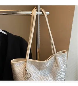 Détail d'un sac cabas beige avec motif géométrique et fines bretelles en cuir synthétique