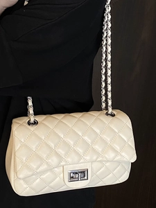 Quilted off-white chain bag with diamond stitching and silver turn-lock closure