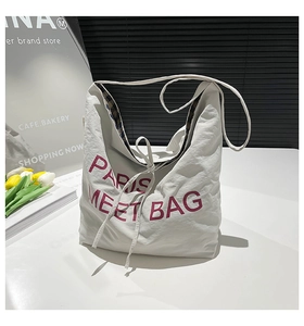 Detail of white large capacity tote bag featuring red Paris Meet Bag embroidery design