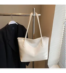 Vue détaillée de la texture du cuir ivoire souple sur un grand sac cabas minimaliste chic