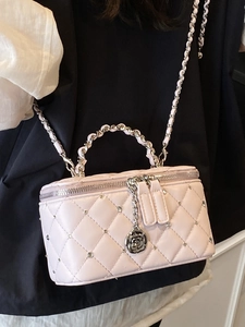 Pink quilted vanity crossbody bag with stud accents and rose charm on a model