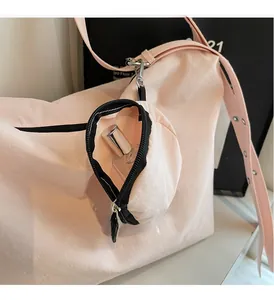 Detail of pink nylon tote bag with small detachable pouch showing storage for perfume
