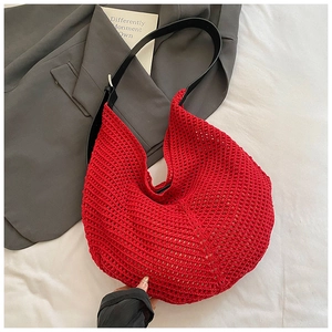 Detail of red hollow knit hobo bag featuring black leather strap and silver buckle closure