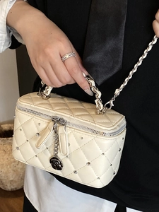 Quilted cream box bag with rhinestone accents, camellia charm, and silver chain strap