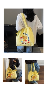 Detail of yellow canvas tote bag with plush bear embroidery and drawstring closure