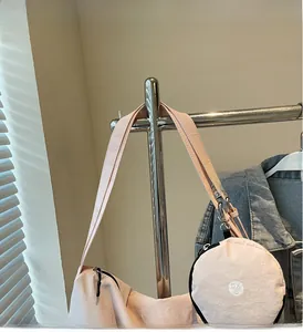 Detail of light pink canvas shoulder bag with a round zip pouch and DXS logo