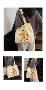 Detail of off-white canvas tote bag featuring cute cartoon bear and blue happiness embroidery