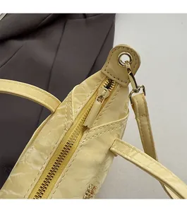 Détail du sac cabas jaune motif crocodile avec fermeture éclair et ferrures métalliques