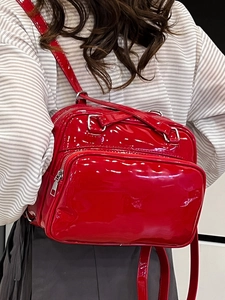 Chic red patent leather convertible backpack with silver hardware in a high-gloss finish