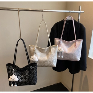 Détails de sacs fourre-tout à gaufrage géométrique en noir, blanc et rose avec porte-clés