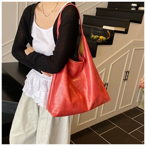 Detailed view of red retro leather tote bag with natural texture and high gloss finish