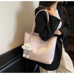 Détail du sac cabas en jacquard rose avec motifs géométriques et breloque nuage en peluche