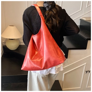Detailed back view of a high-capacity red leather Hobo shoulder bag worn by a model