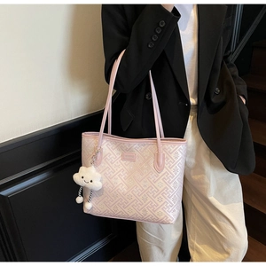 Détail du sac cabas rose avec texture géométrique et charmant accessoire nuage en peluche