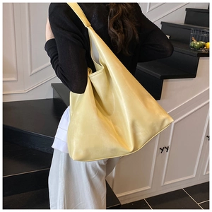 Detail of soft cream leather tote bag showing smooth texture and slouchy shoulder design