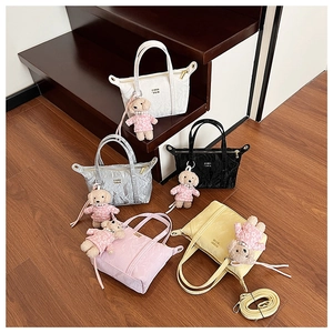 Détail de mini sacs cabas en cinq couleurs avec breloques chiot fleuries et perles