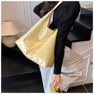 Lifestyle shot of a spacious light yellow hobo tote bag shown on a female model