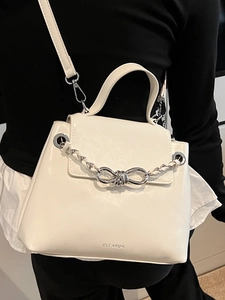 White minimalist crossbody bag with silver woven metal bow and top handle for women