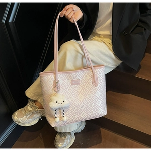 Détail d'un grand sac cabas avec motif jacquard floral et accessoire peluche en forme de nuage