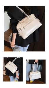 Detail view of cream white bowling bag featuring multi-pocket design and silver zippers