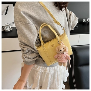 Détail du mini sac cabas jaune vif avec logo COIN SON et breloque ours rose