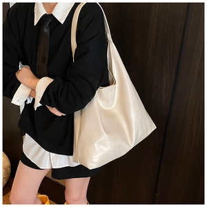Side view of a large cream beige tote bag showing its capacity and soft PU leather texture
