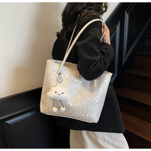 Détail du sac cabas crème avec gaufré avec un pendentif en peluche en forme de nuage mignon