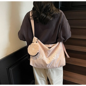 Detail of a large pink canvas tote bag with shoulder strap and a small coin purse