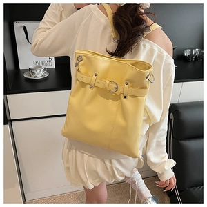 Detail shot of bright yellow drawstring backpack with silver ring buckle and metal hook