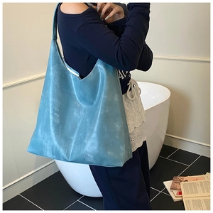 Close-up of light blue leather tote bag showing vintage texture and large capacity