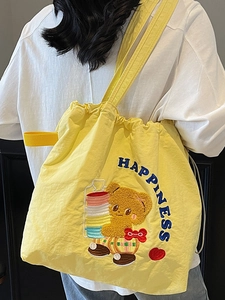 Yellow drawstring tote bag with cute bear embroidery and blue HAPPINESS text design