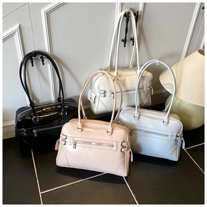Detail view of four colorful glossy patent leather tote bags with metal buckles in a row