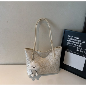 Détail du sac cabas beige avec motifs géométriques et charmant nuage en peluche