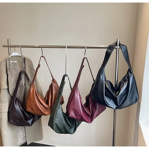 Detailed display of vintage hobo bags in deep brown, orange, green, burgundy, and black