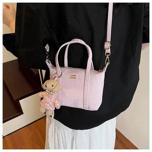 Mini sac cabas plissé rose avec breloque chien en peluche et bandoulière sur modèle