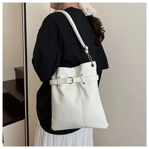 Detail view of the white large bucket bag showing the metal buckle and side ring texture