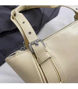 Détail de la boucle en métal argenté et couture précise du sac bandoulière crème