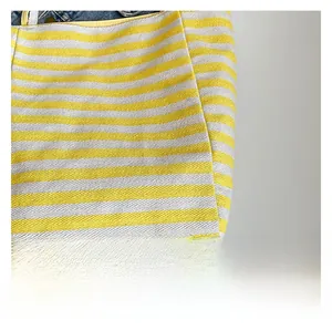 Vue détaillée du sac cabas en toile rayé jaune et blanc avec texture en sergé