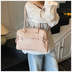 Detail of pink glossy leather bowling bag featuring silver buckles and side pocket detail