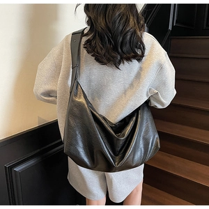 Model view of large black oil-wax leather shoulder bag with chic slouchy design