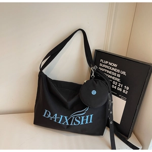 Close-up of black canvas crossbody bag with blue logo and matching round coin purse