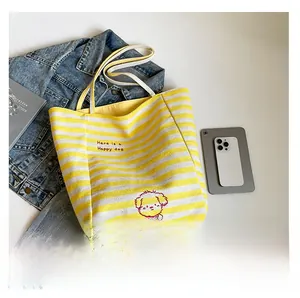 Détail d'un sac cabas en toile à rayures jaunes avec imprimé chien de dessin animé