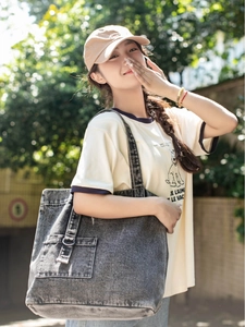 Deep grey washed denim tote bag with oversized shoulder strap and decorative metal D-ring