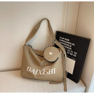 Detail of khaki nylon crossbody bag with matching round coin purse and white text logo