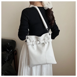 Detailed back view of a large white drawstring bucket bag with decorative buckle on a model