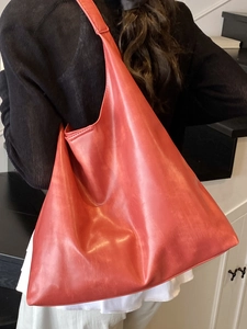 Minimalist coral red leather tote bag with large capacity and soft hobo style shoulder strap