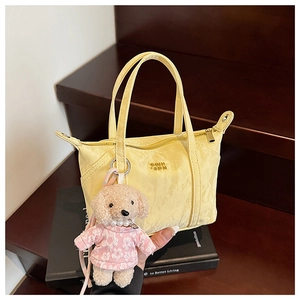 Vue détaillée du mini sac cabas jaune avec texture froissée et pendentif ours en peluche