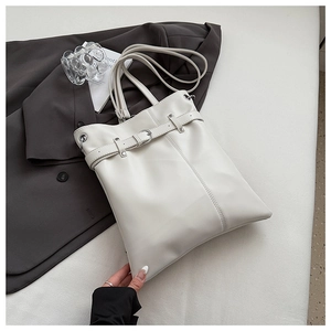 Detail of off-white leather bucket bag showing silver buckle and decorative stitching