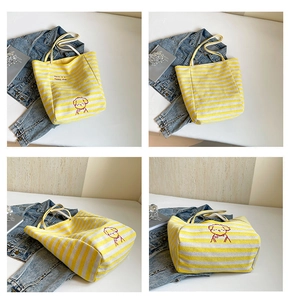 Détail du sac cabas en toile rayée jaune avec broderie de chien et lettrage